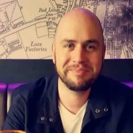 Professional man smiling in a modern office environment with a city map background, representing digital marketing expertise.